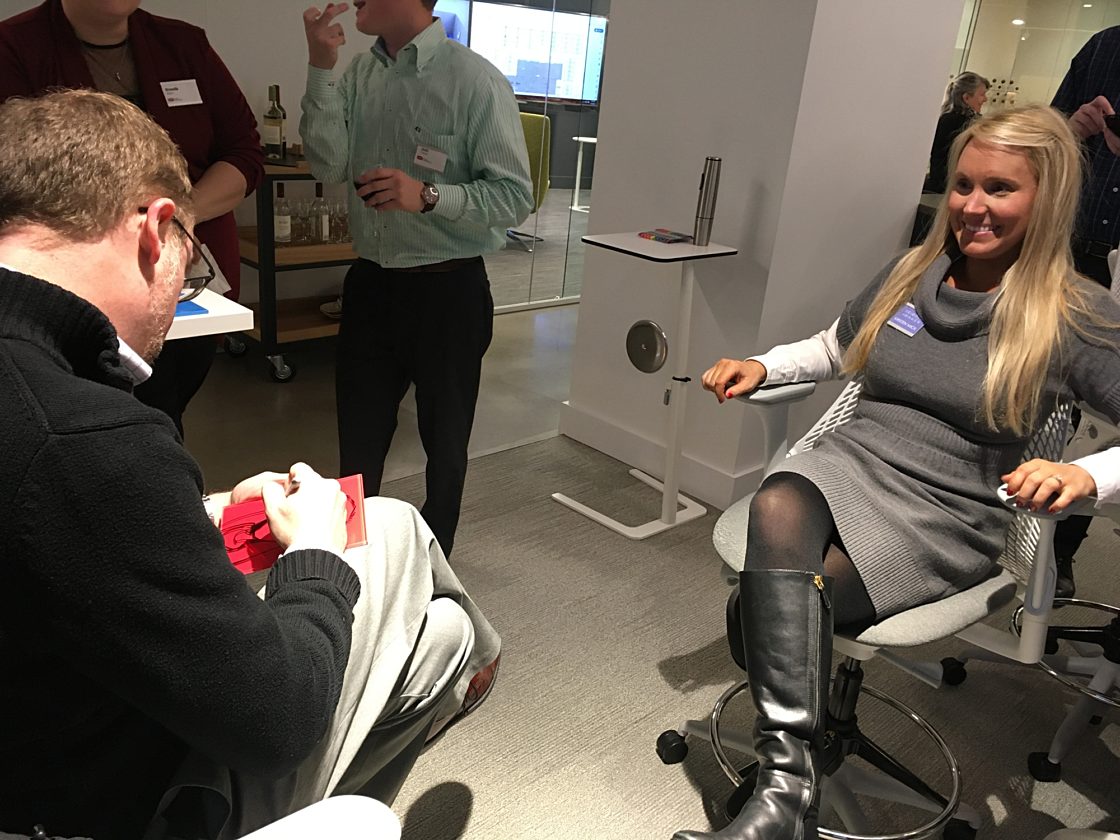 A caricaturist draws the picture of a young blond woman on glass during the event happy hour.