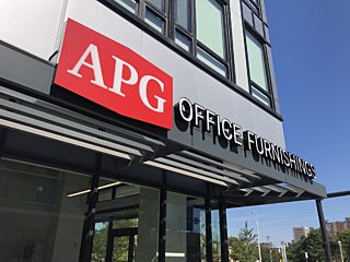 Exterior of the APG Cleveland showroom. Warm, sunny day with green trees in the background.