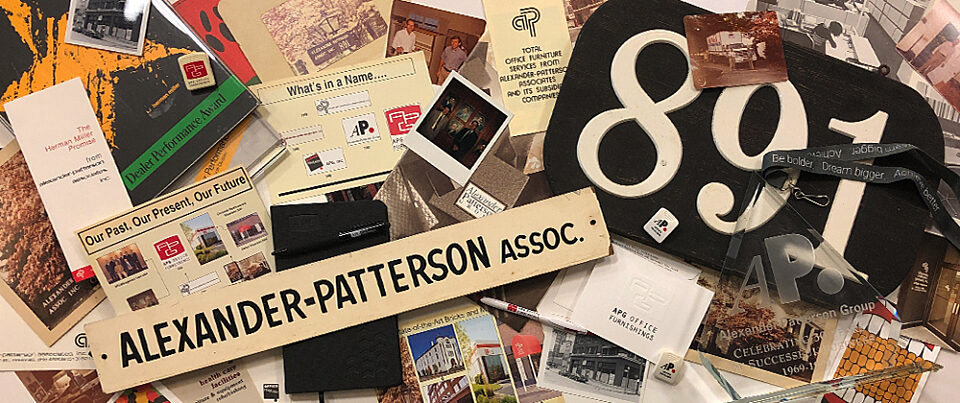 Flat-lay collage of APG memorabilia from the archive: historic photos, promotional materials, brochures, awards, signage.