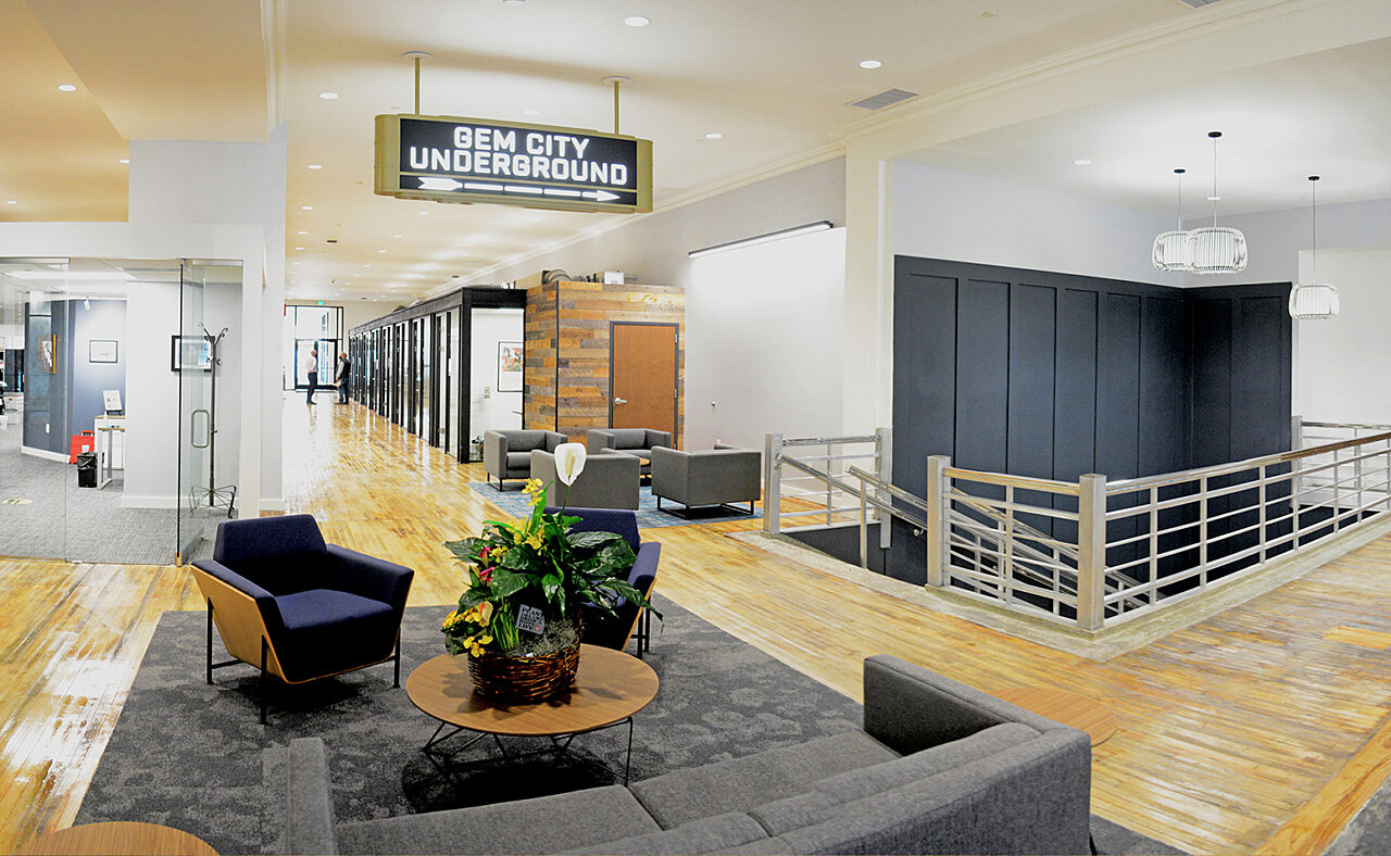 A stylish office building lobby with an expansive wooden floor, highlighting modern design and inviting ambiance.