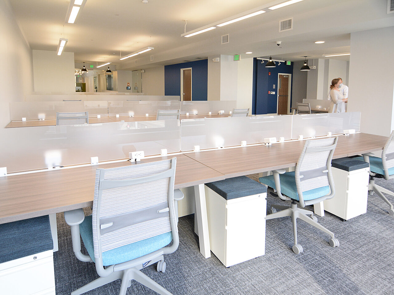 A large office area containing various desks and chairs, designed for a collaborative work environment.