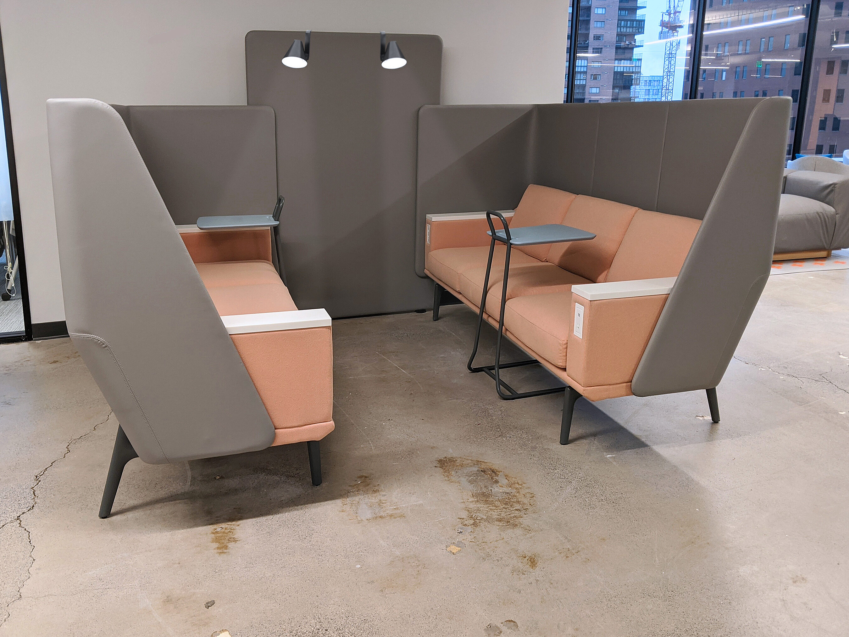 Modern-style booth arrangement for small, casual meetings. Coral seats with ash-grey high backs and integrated lighting. Pull-up table for ease of work